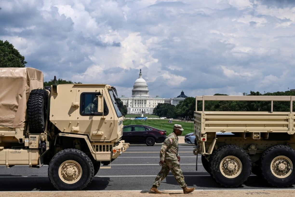A member of the US National Guard walks past military vehicles on the National Mall in Washington