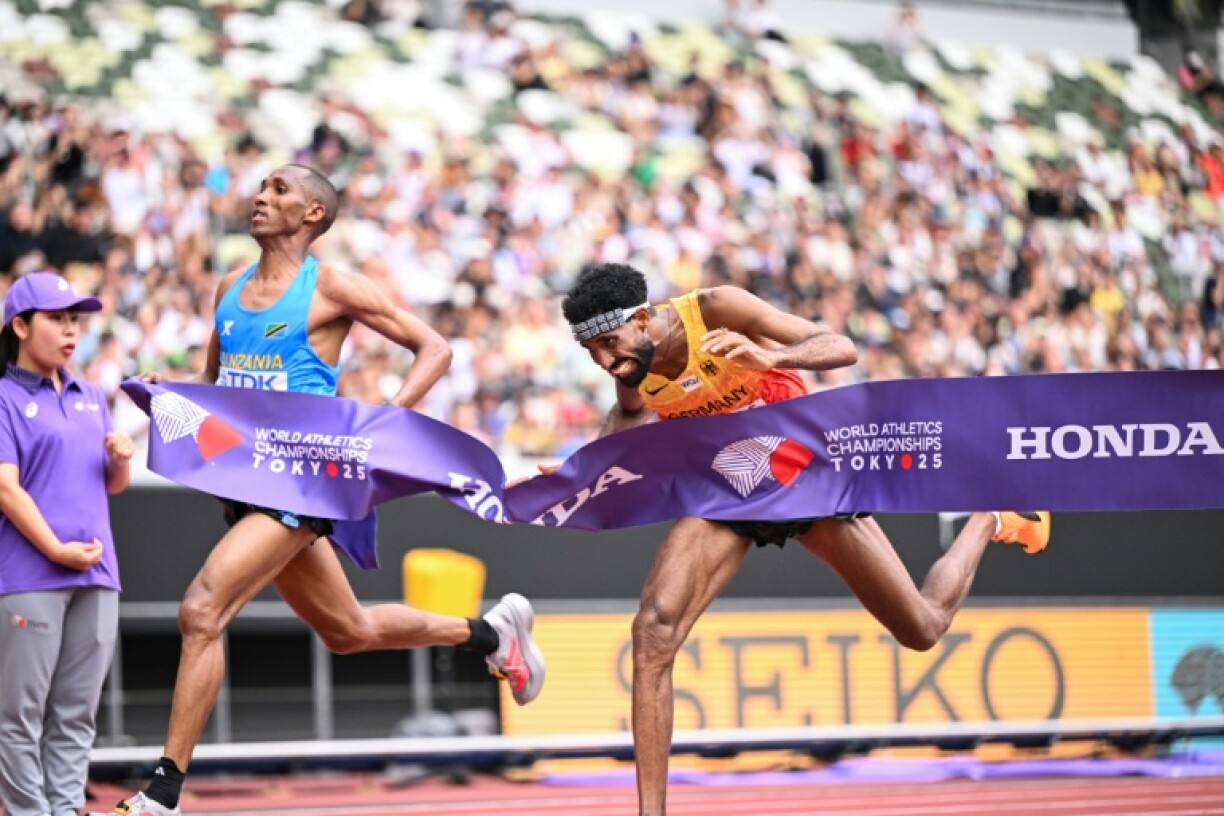 Germany's athlete Amanal Petros (R) and Tanzania's Alphonce Felix Simbu cross the finish line in the men's marathon