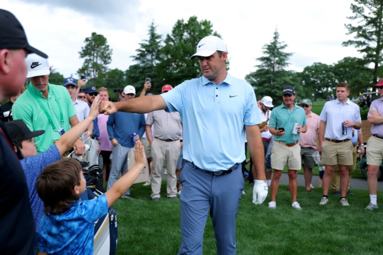 World number one Scottie Scheffler of the United States fist-bumps young fans during a practice round for the 107th PGA Championship at Quail Hollow
