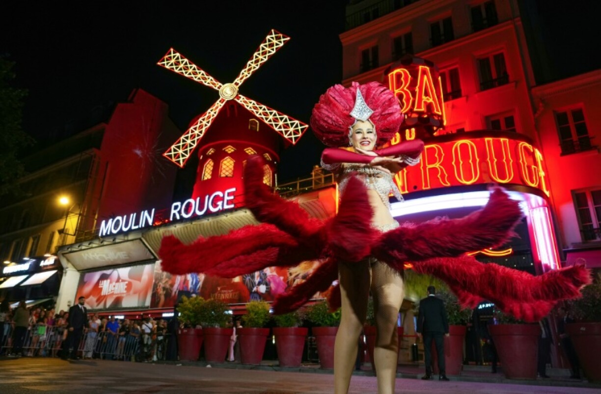 A dancer performs under the new the sails of The Moulin Rouge cabaret windmill, which went back into service 14 months after they fell off