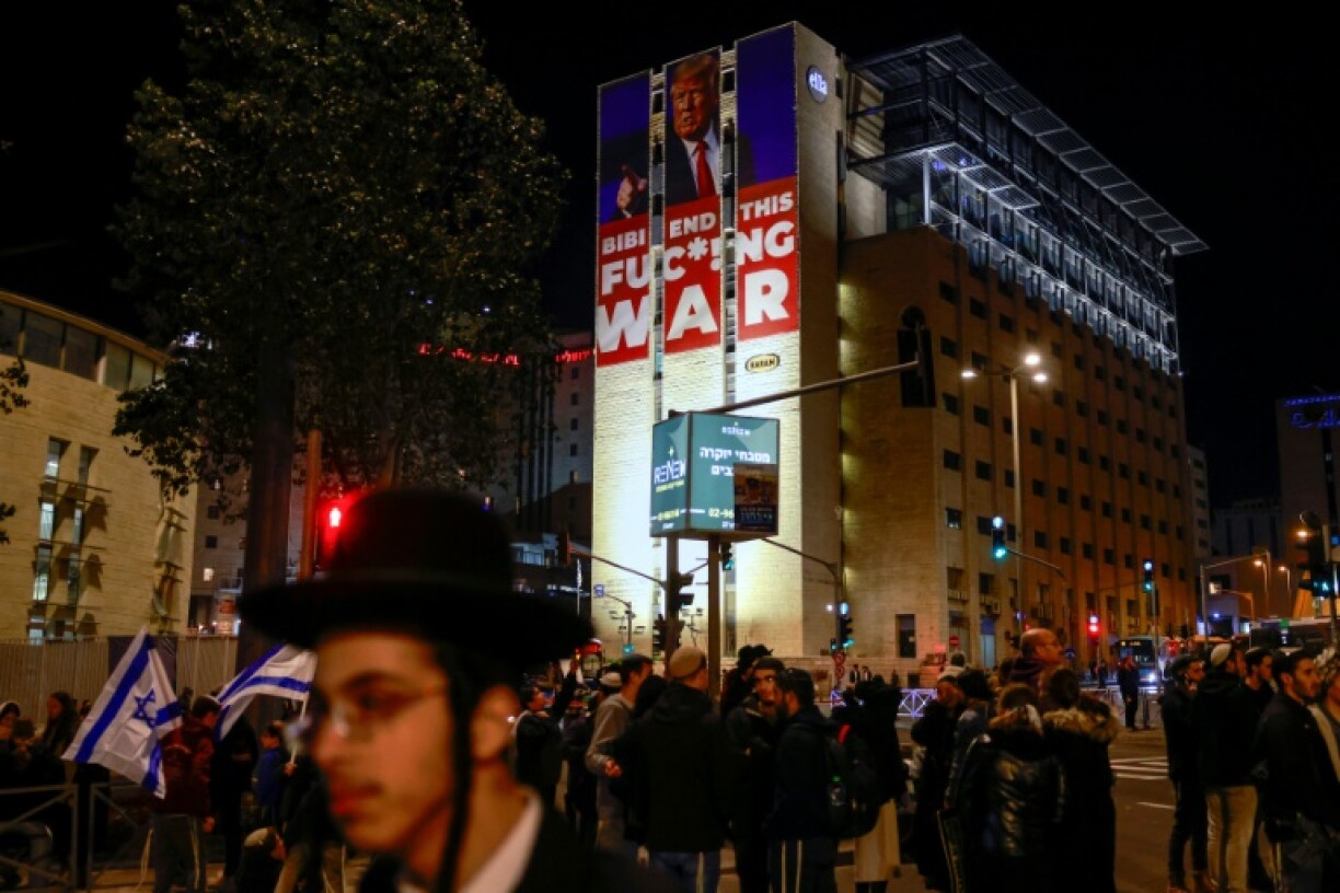 A billboard calling for an end of the war between Israel and Hamas along with a portrait of US President-elect Donald Trump stands on top of a building in Jerusalem