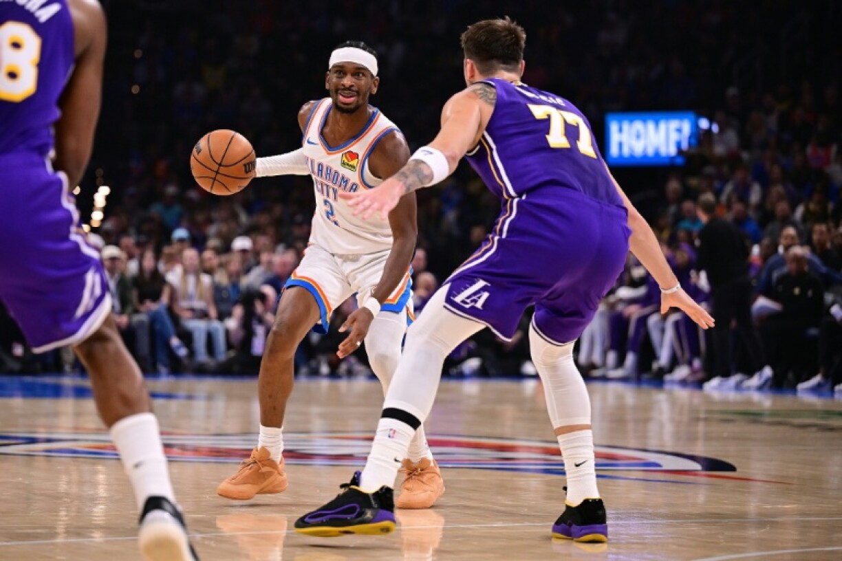 Shai Gilgeous-Alexander of the Oklahoma City Thunder looks for an opening against Luka Doncic in the Thunder's NBA win over the Los Angeles Lakers