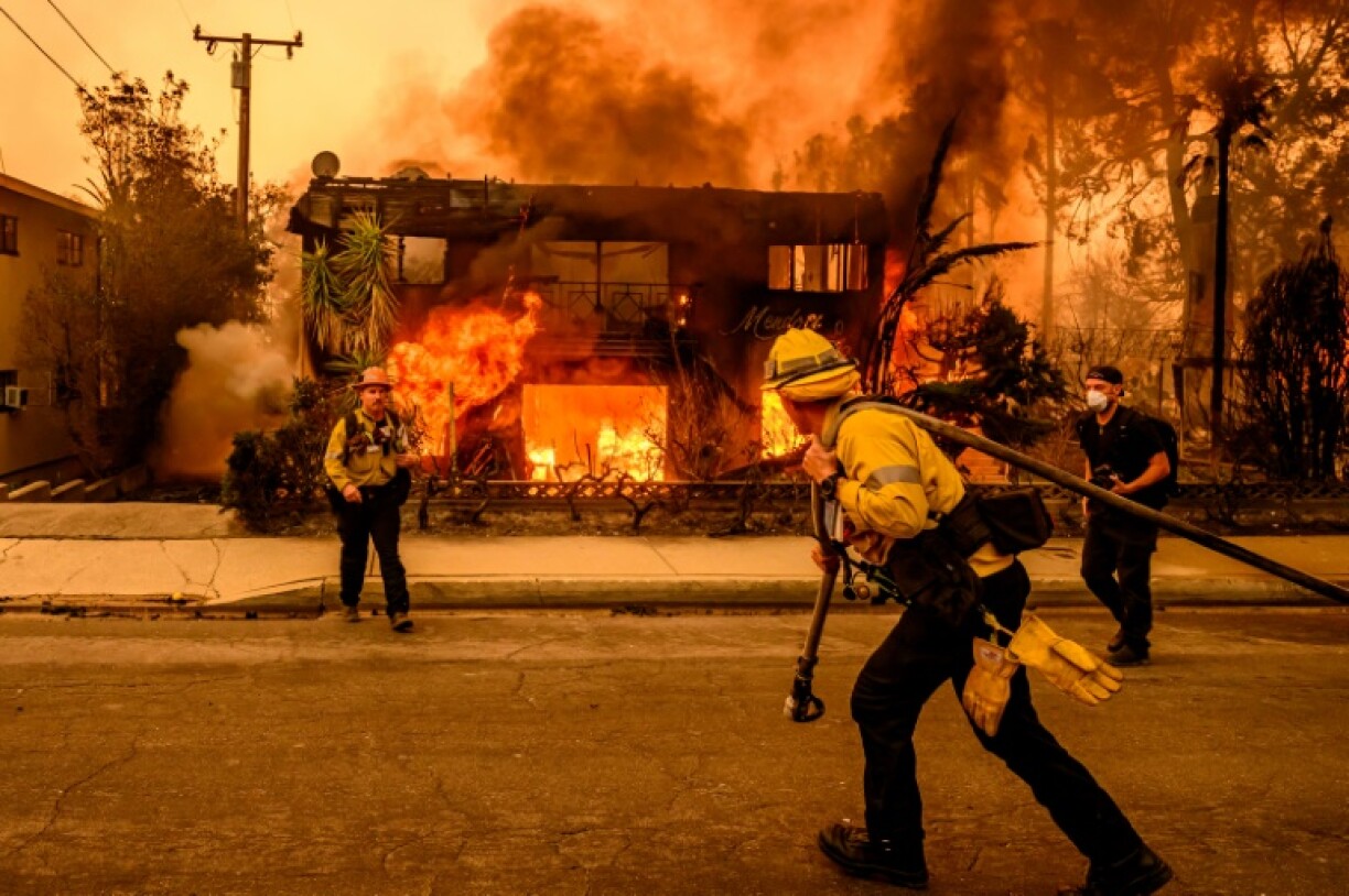 Firefighters work at an apartment burning in the Eaton fire in the Altadena area of Los Angeles County on January 8, 2025