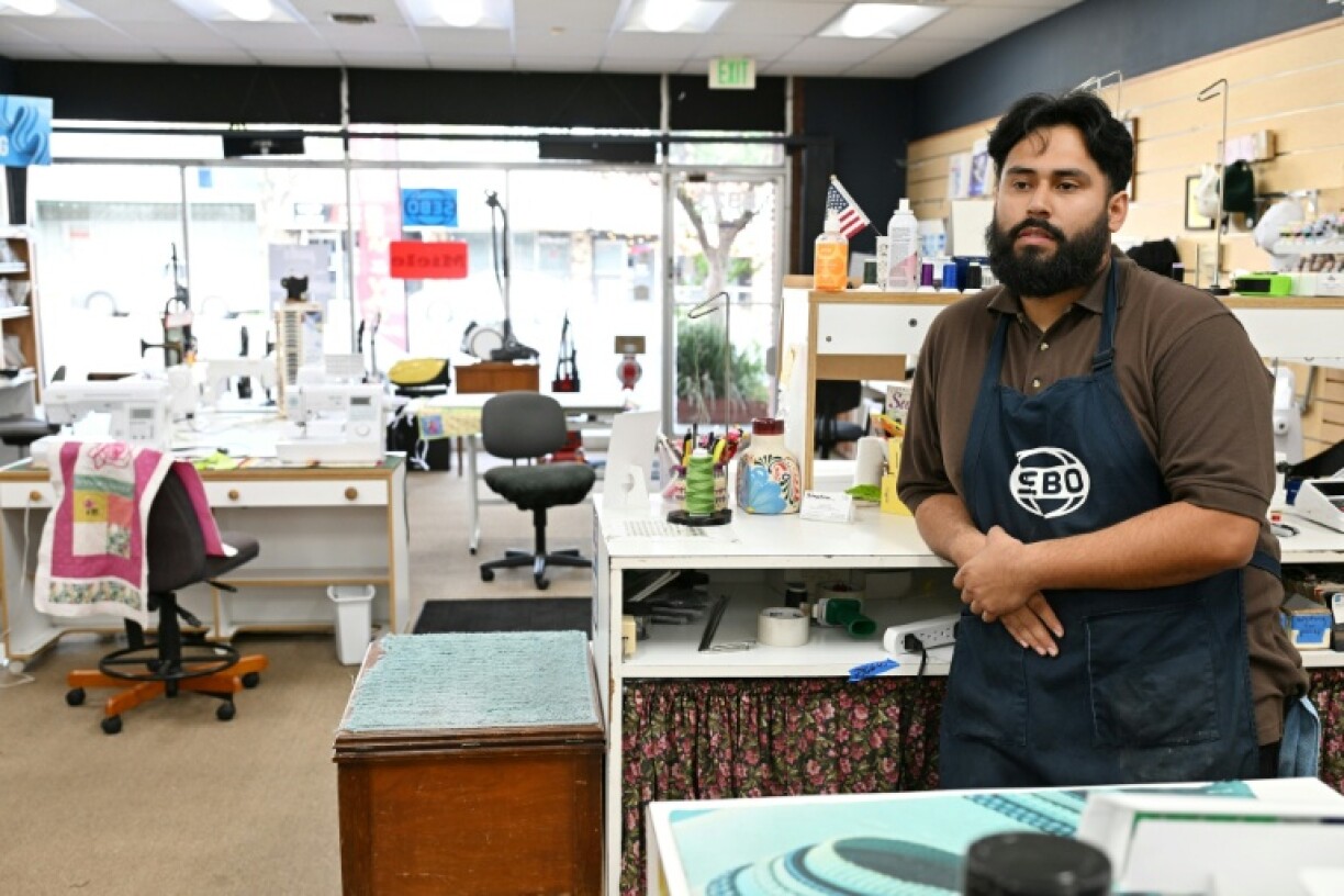 Angel De Luna waits for customers at his family-owned Kingdom Sewing & Vacuum Center, where the tariffs are shaping up to be a threat to businesses like his