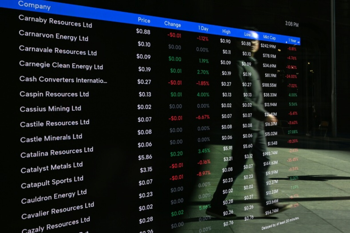 A pedestrian is reflected in a display at the Sydney Stock Exchange building on September 29, 2026