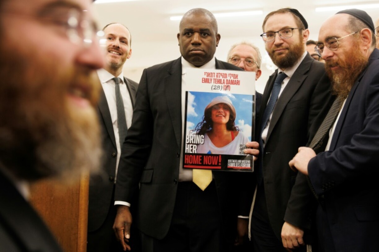 Britain's Foreign Secretary David Lammy holding a poster showing hostage Emily Damari