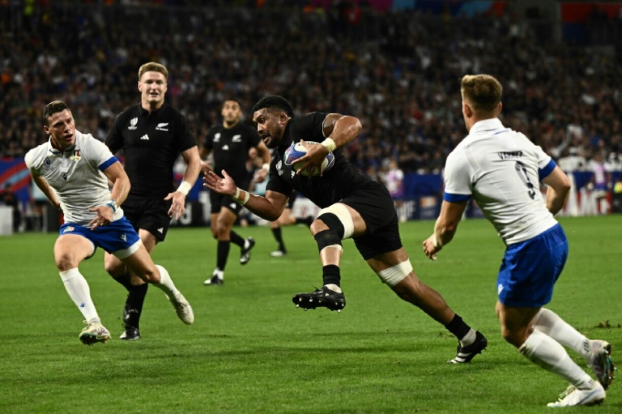 Le troisième ligne et capitaine de la Nouvelle-Zélande Ardie Savea (au centre) en train d'inscrire un essai lors de la victoire 96-17 contre l'Italie lors de la Coupe du monde de rugby à Décines-Charpieu près de Lyon, France, le 29 septembre 2023