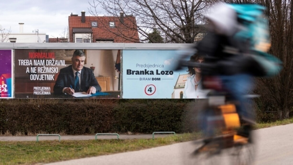 Un homme à vélo passe devant une affiche électorale du président croate sortant et candidat à la présidentielle, Zoran Milanovic, à Zagreb, le 9 janvier 2025