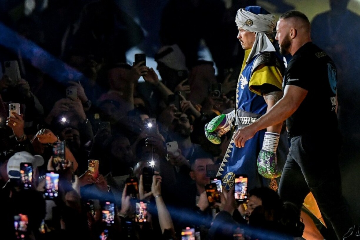 Ukraine's Oleksandr Usyk (L) says he will carry on boxing to fund the war effort and regain the status of undisputed heavyweight world champion