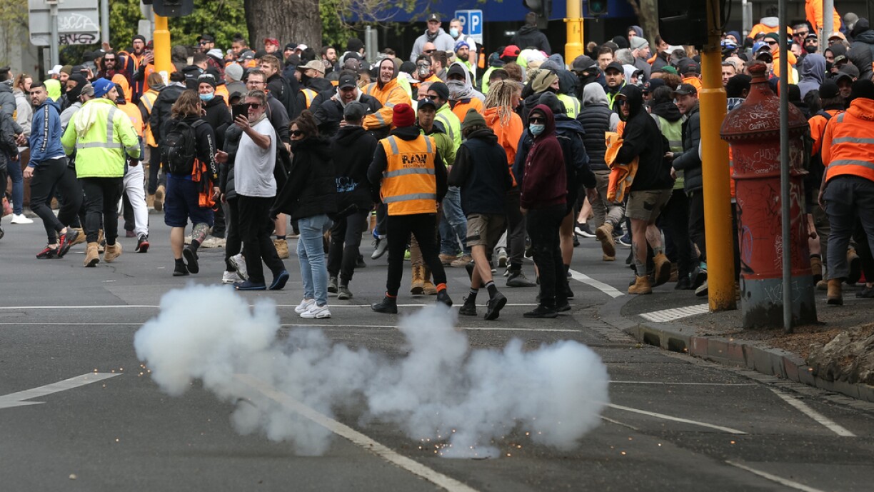 Police throw a stinger grenade as demonstrators protest against Covid-19 regulations in Melbourne on September 21, 2021.