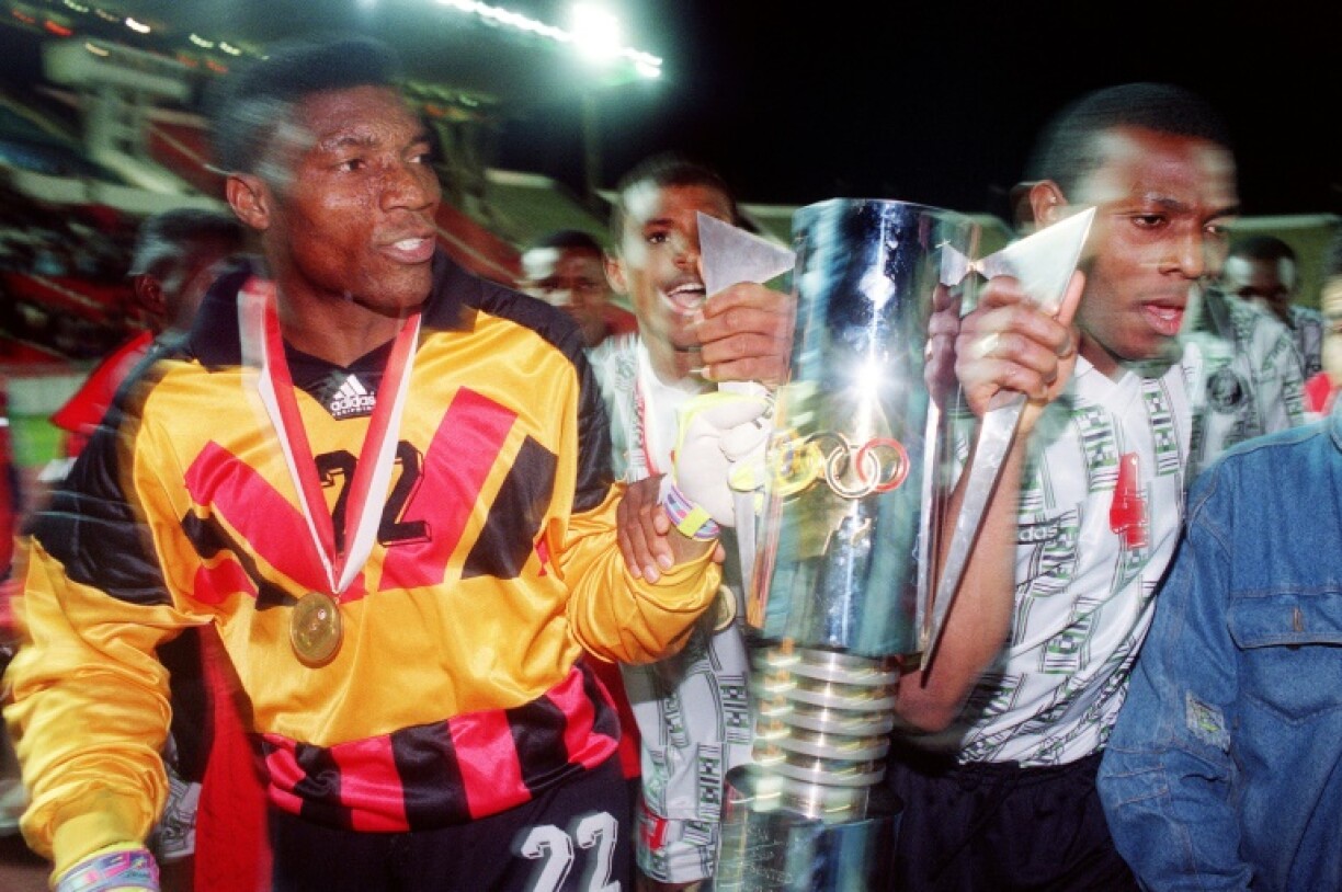 Nigerian goalie Peter Rufai (L) holds the African Nations Cup trophy won in 1994 against Zambia in Tunis