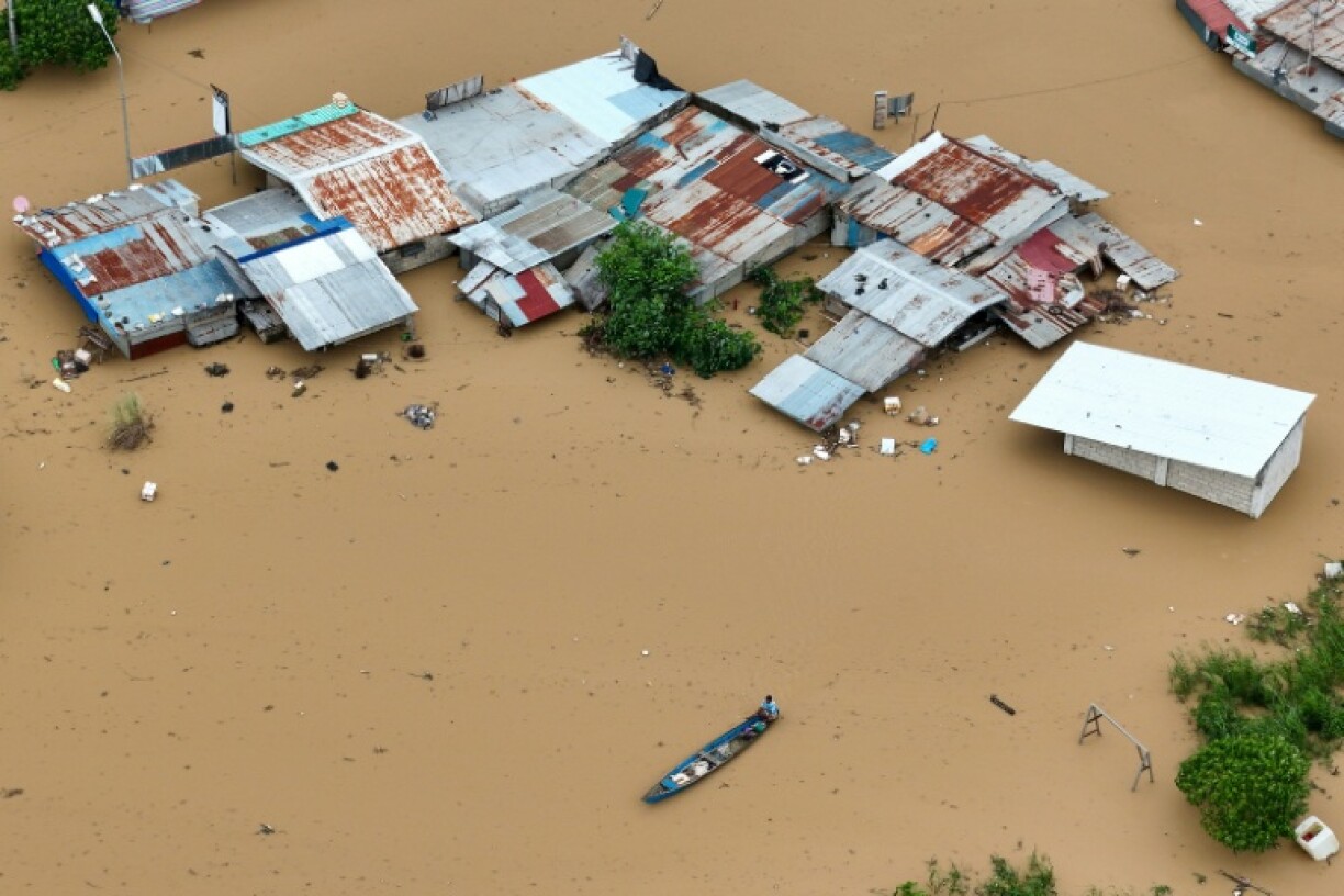 A resident paddles his boat past inundated houses in the Philippines' Tuguegarao City, in the wake of Typhoon Fung-wong