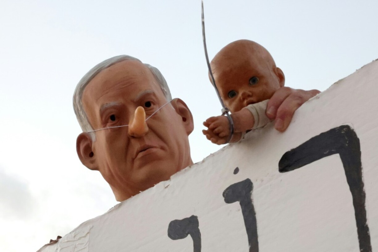 Israeli Prime Minister Benjamin Netanyahu, seen here as a caricature at a protest in Tel Aviv, is under mounting domestic and international political pressure