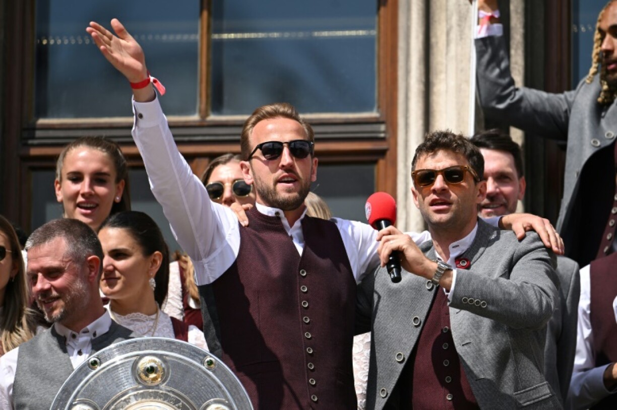 Bayern Munich forwards Harry Kane (L) and Thomas Mueller celebrate the 2024-25 Bundesliga title