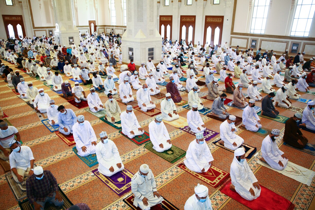 Mask-clad men perform the Friday prayers at the Sayeda Fatima mosque in the Omani capital Muscat for the first time in eighteen months, after some restrictions that had been put in place by the authorities in a bid to stem the spread of the coronavirus were lifted