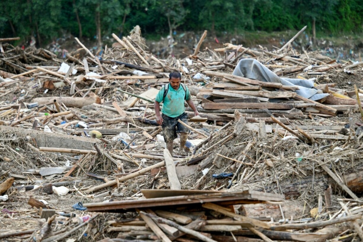A man walks amid the remains of a landslide-affected area following heavy rains in Lalitpur district on the outskirts of Kathmandu in 2024