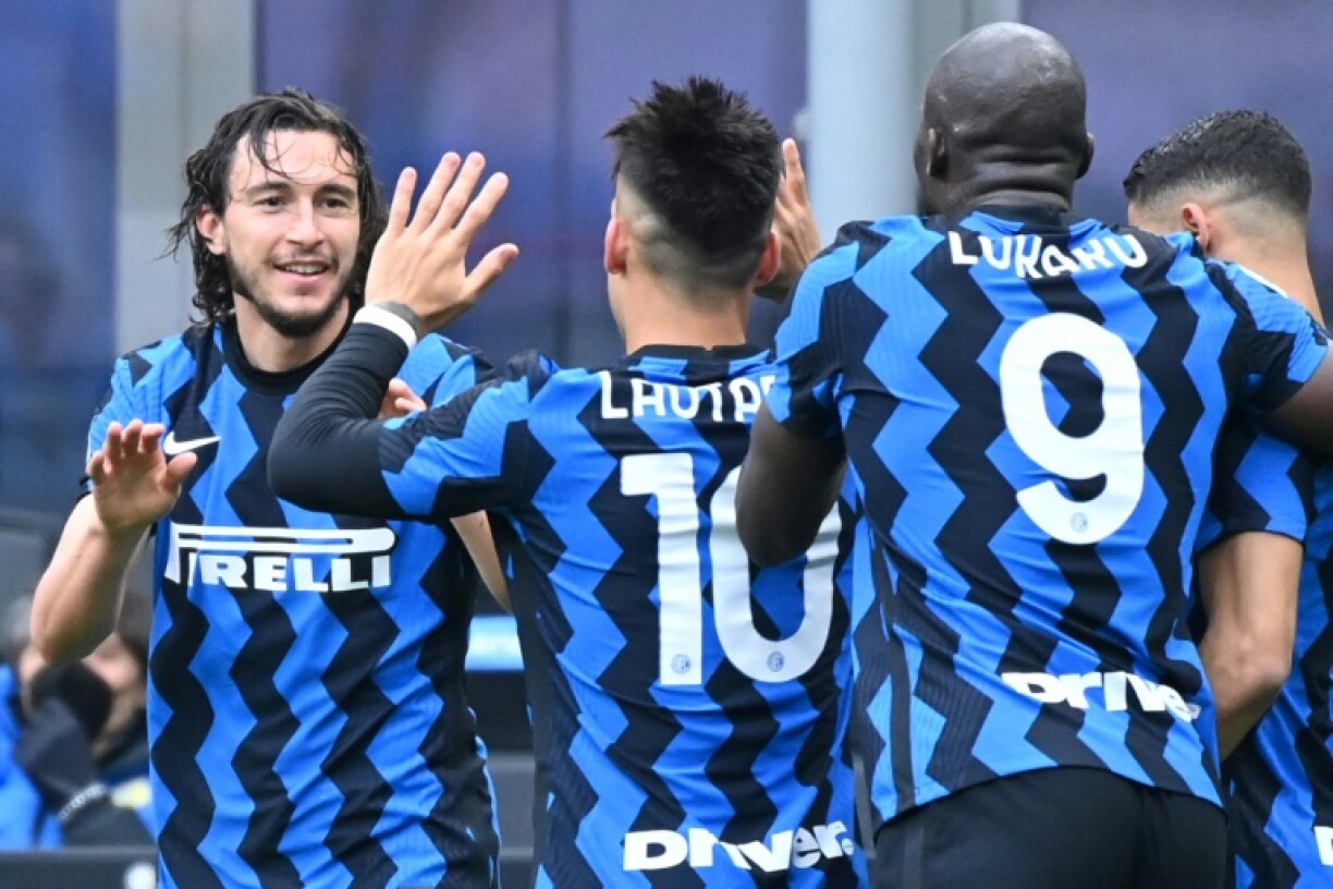 La joie du défenseur de l'Inter Milan, Matteo Darmian (g), félicité par ses coéquipiers, après avoir ouvert le score à domicile contre Cagliari, lors de leur match de Série A, le 11 avril 2021 au stade San Siro