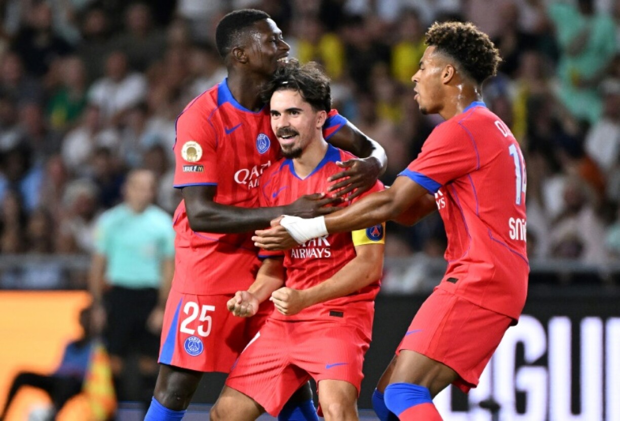 Vitinha (C) celebrates with teammates Nuno Mendes and Desire Doue after scoring Paris Saint-Germain's winning goal against Nantes