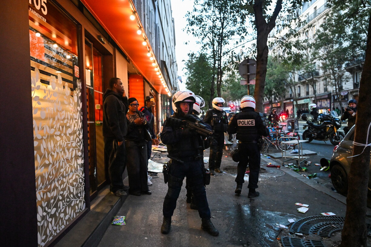 Police officers stand in front of a ransacked Franprix store as clashes erupted at Place de la Republique following an unauthorised demonstration, central Paris, on October 18, 2026 a day after nationwide protests against the "high cost of living".