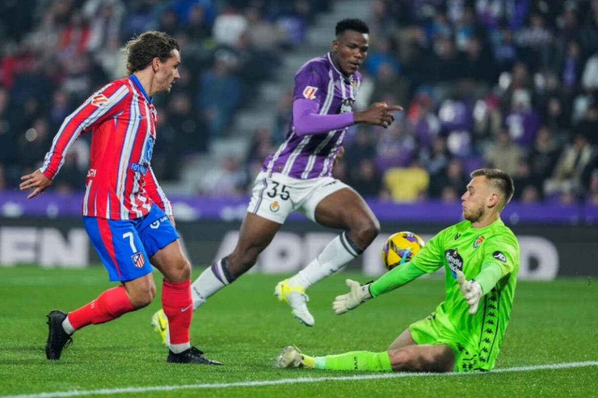 Atletico Madrid's French forward Antoine Griezmann (L) scores past Real Valladolid keeper Karl Jakob Hein
