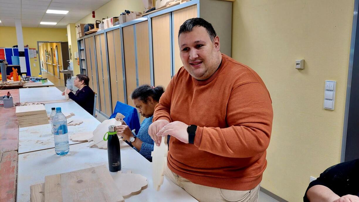 Den Daniel Sousa bei der Aarbecht, wéi hien Holz schläift.