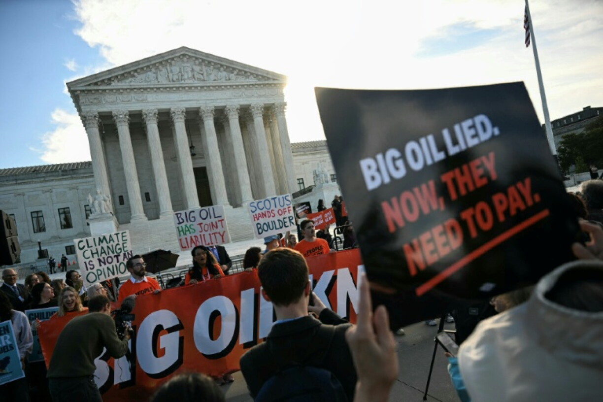 Protestors gather outside the US Supreme Court as it hears a climate case that could upend dozens of lawsuits aimed at making oil companies pay for their role in global warming