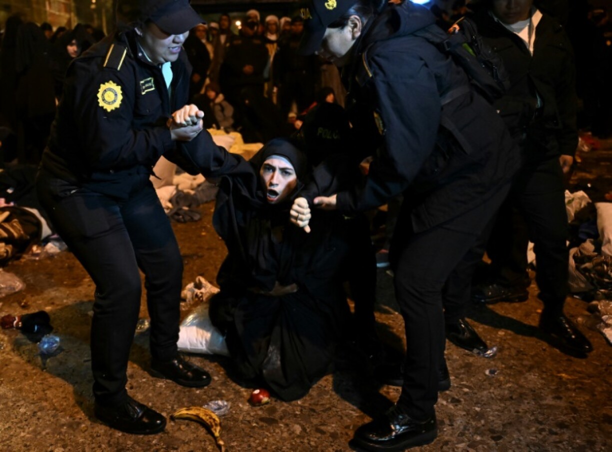 Police remove a woman demanding the release of children taken by authorities from an ultra-orthodox Jewish sect in Guatemala