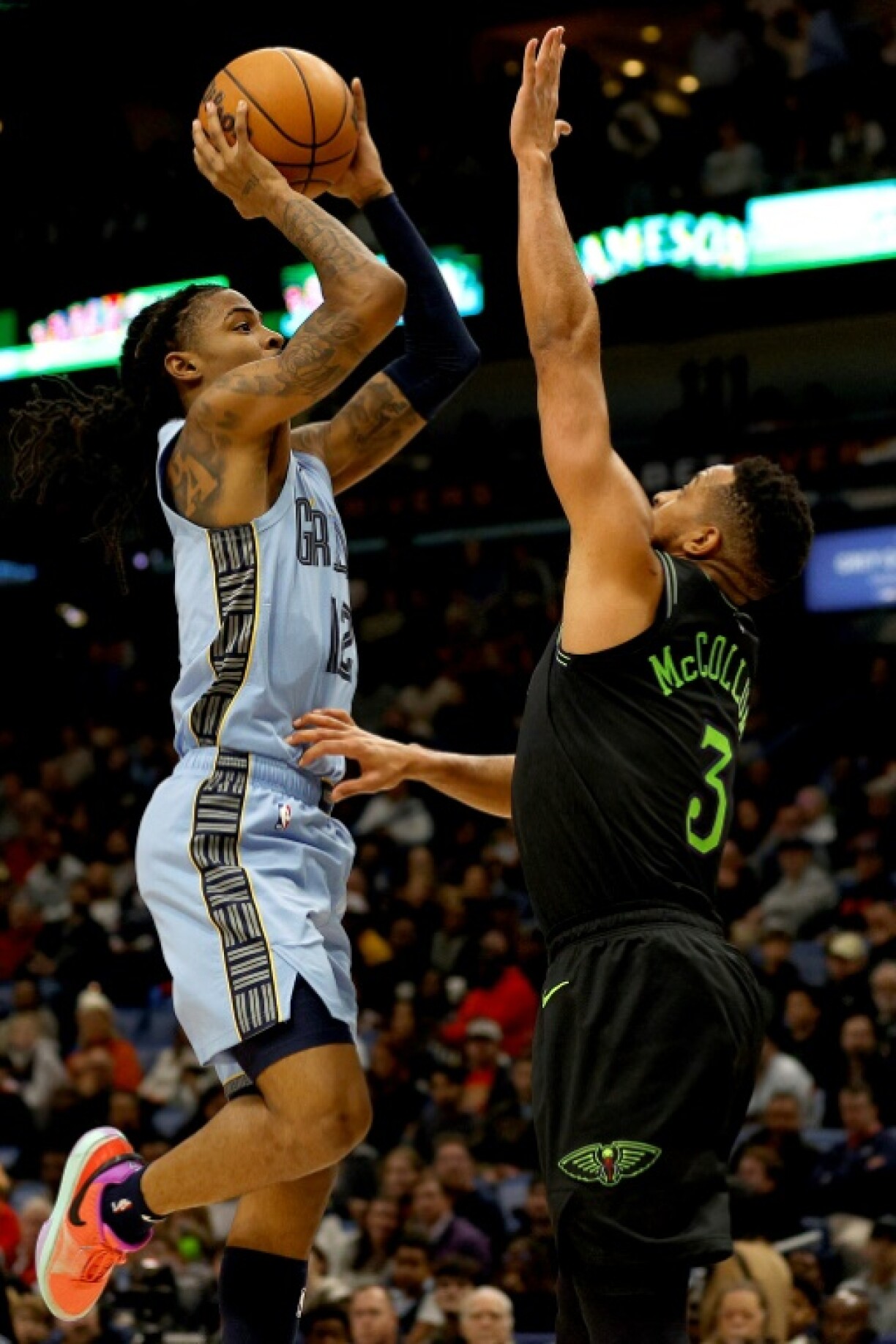 Ja Morant des Memphis Grizzlies shoote malgré la présence de CJ McCollum des New Orleans en NBA le 26 décembre 2023 à la Nouvelle Orléans