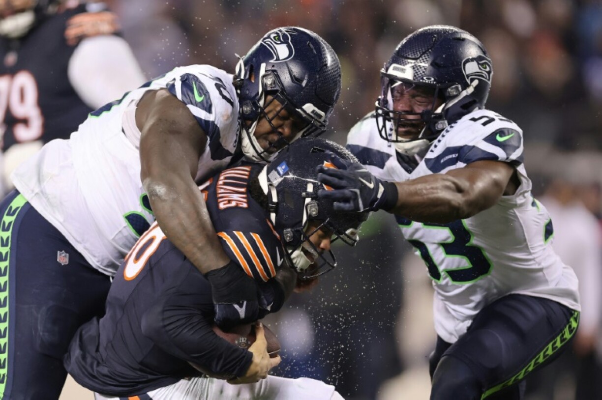 Seattle's Jarran Reed, left, sacks Chicago quarterback Caleb Williams in a defense-dominated 6-3 NFL victory over the Bears