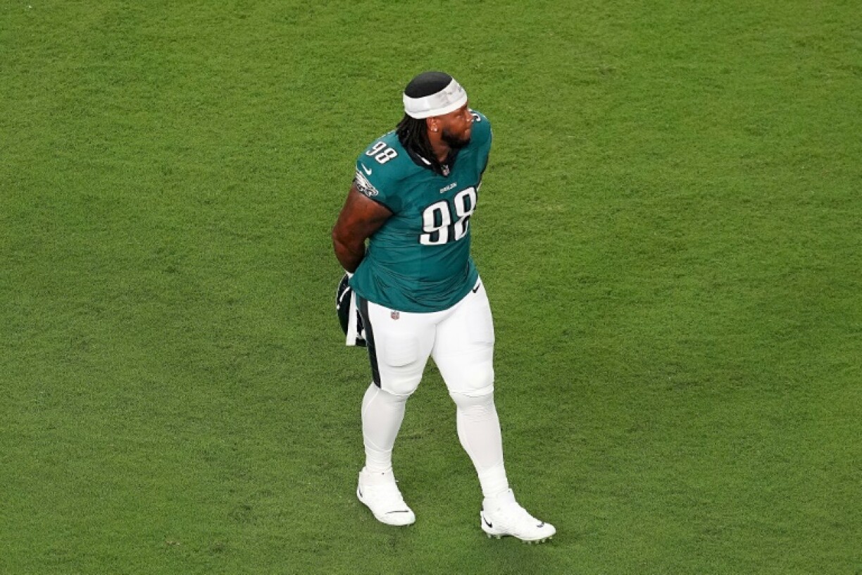 The Philadelphia Eagles' Jalen Carter walks off the field after being ejected for spitting at Dallas quarterback Dak Prescott