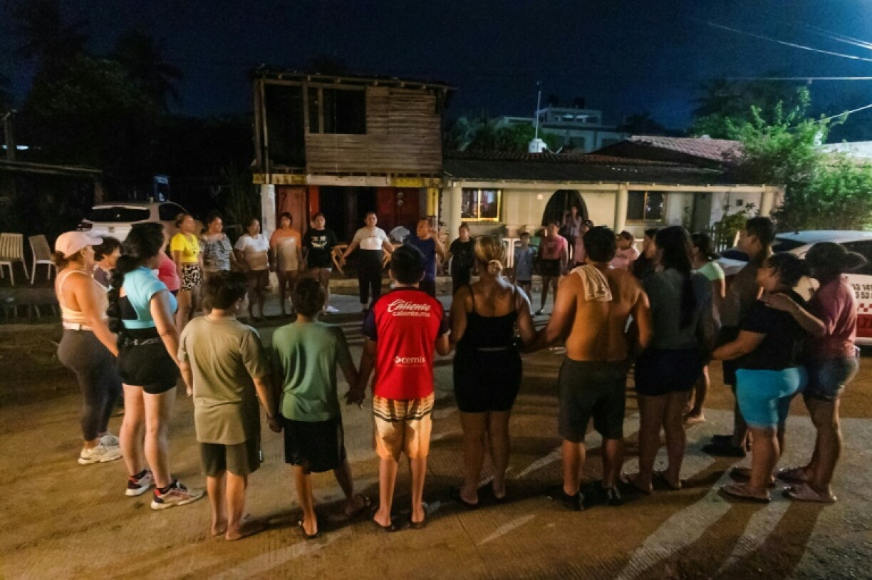 Residents pray as Hurricane Polo passes Playa Azul beach in the municipality of Lazaro Cardenas, Michoacan, Mexico
