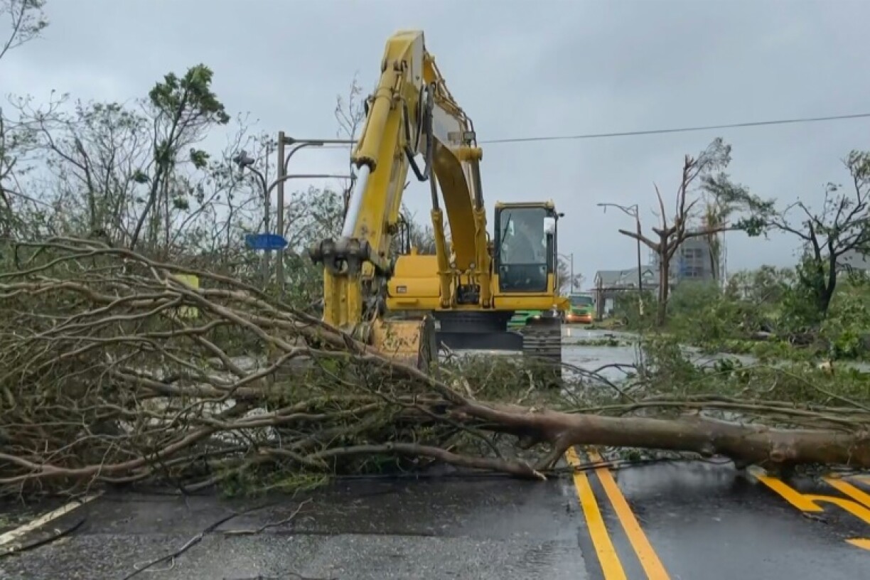 Image tirée d'une vidéo de l'AFPTV d'une pelleteuse dégageant des arbres tombés en travers d'une route après le passage du typhon Haikui, le 4 septembre 2023 à Taïwan