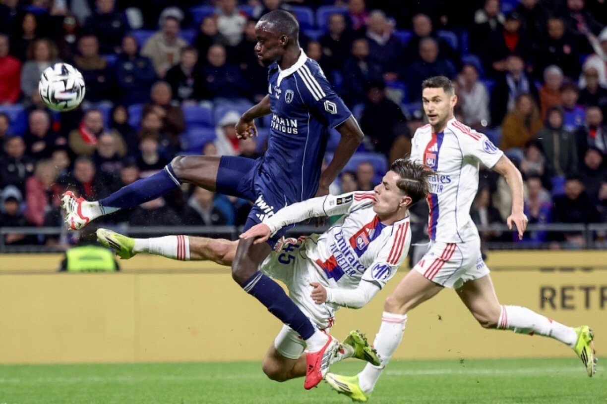 Le défenseur du Paris FC Moustapha Mbow (G) à la lutte avec l'attaquant lyonnais Remi Himbert lors du match nul 1-1, le 8 mars 2026 au Groupama Stadium à Decines-Charpieu