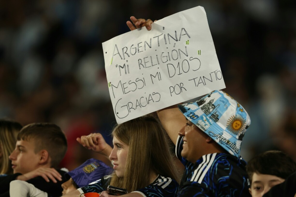 A fan holds up a sign which reads: