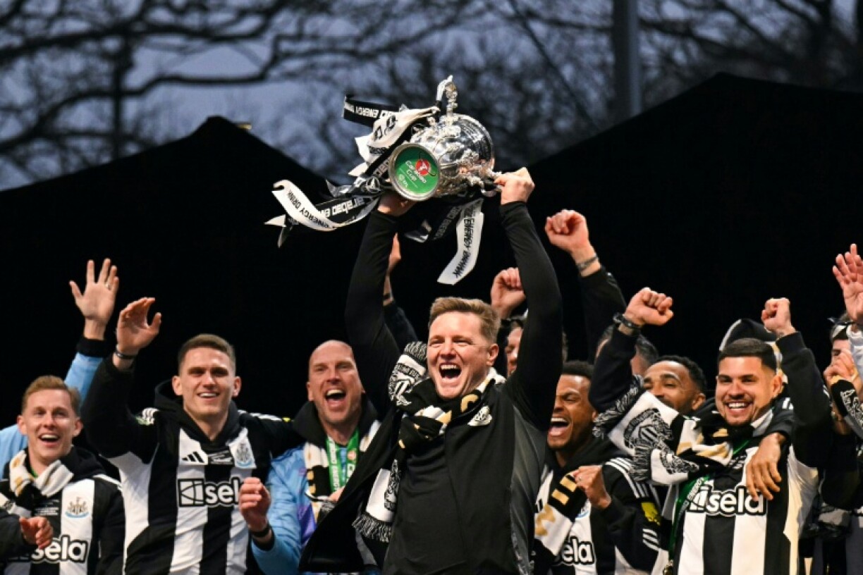 Newcastle manager Eddie Howe lifts the League Cup in front of a crowd of 150,000 celebrating fans