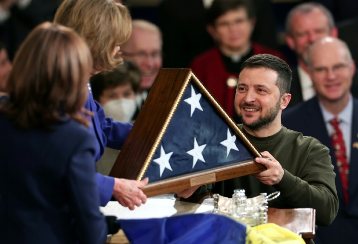Le président ukrainien Volodymyr Zelensky reçoit un drapeau américain après avoir remis un drapeau ukrainien à la présidente de la Chambre des représentants Nancy Pelosi, le 21 décembre 2022 au Capitole, à Washington.