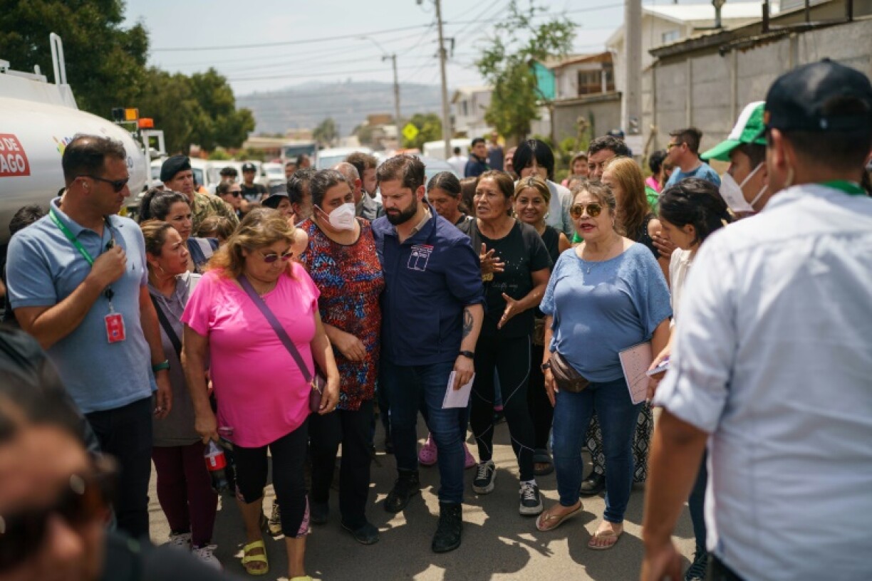 Photo fournie par la présidence chilienne montrant le président Gabriel Boric (au centre) avec des habitants de Quilpué (Chili) ravagée par les incendies, le 4 février 2024