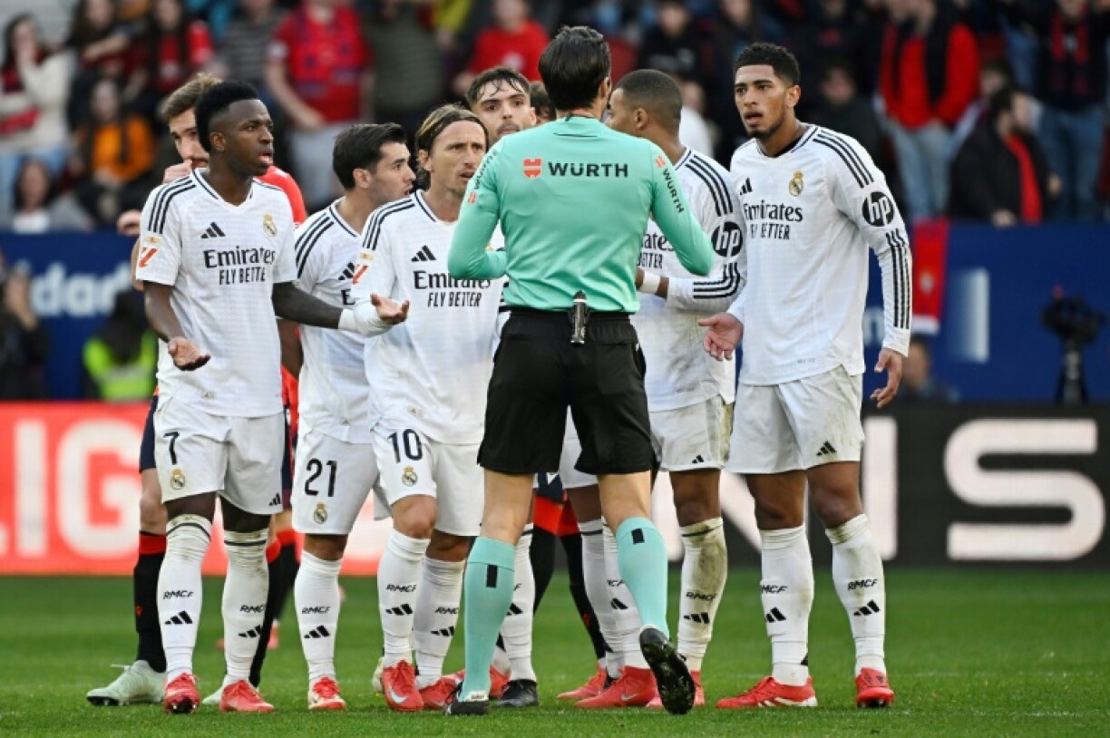 Real Madrid players remonstrate with referee Jose Munuera Montero about Jude Bellingham's (R) red card