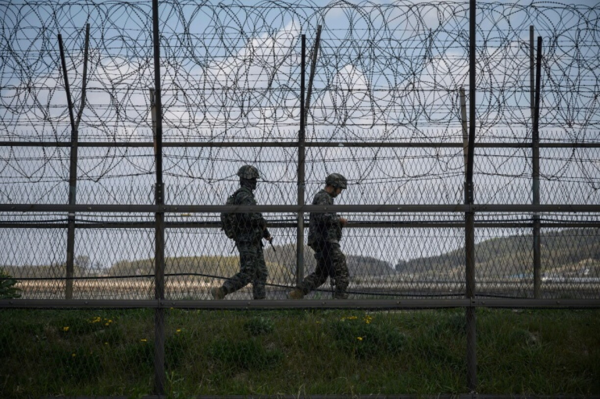 South Korean soldiers patrol along a barbed wire fence Demilitarized Zone (DMZ)