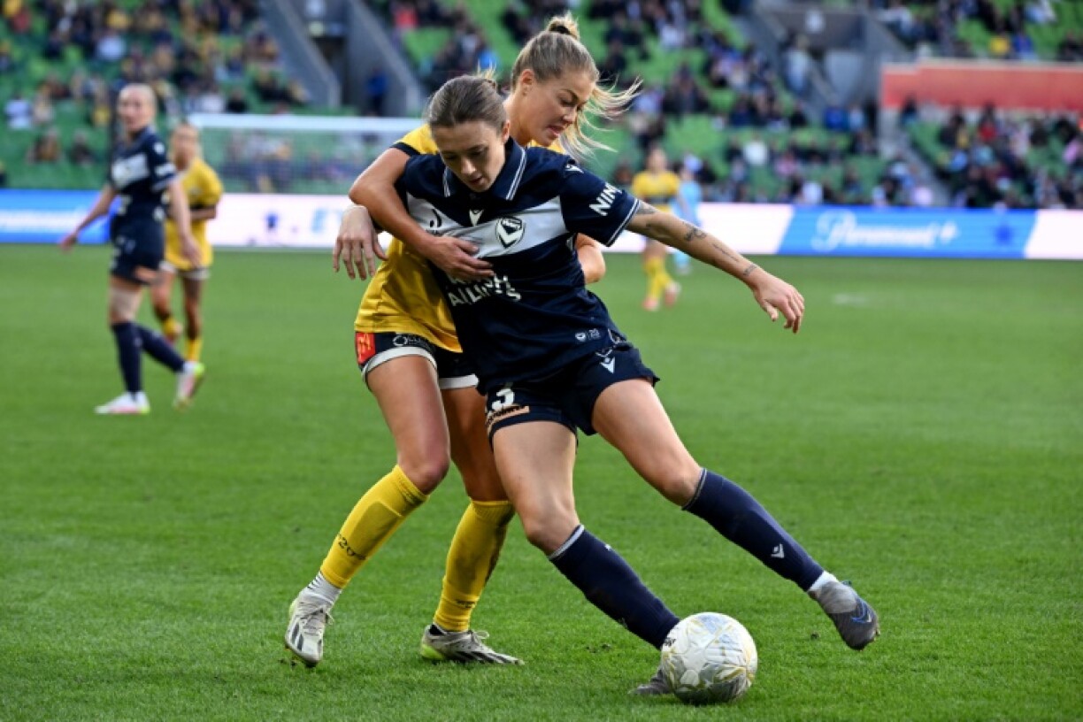 Central Coast Mariners' Sarah Rowe (L) and Melbourne Victory's Claudia Bunge tussle for the ball during the women's A-League football grand final