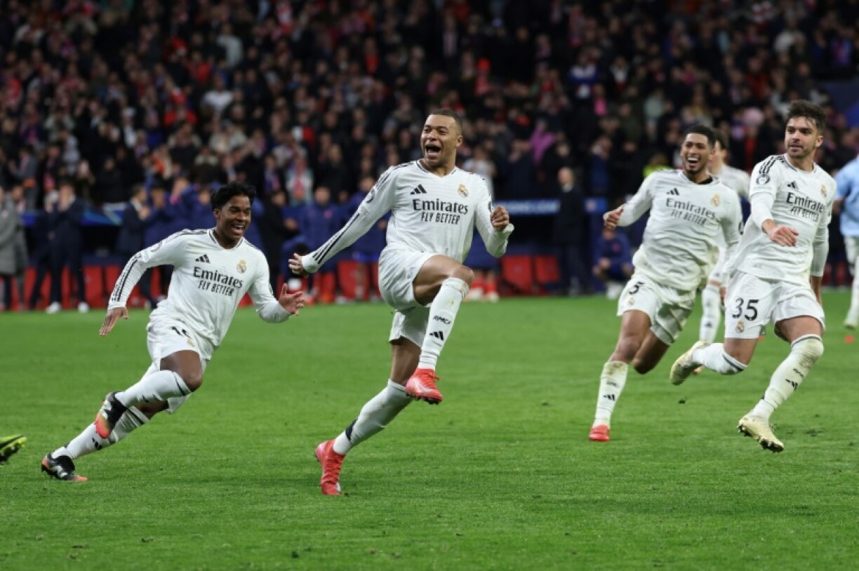 Real Madrid's French forward Kylian Mbappe (C) celebrates with team-mates after the shoot-out win over Atletico Madrid