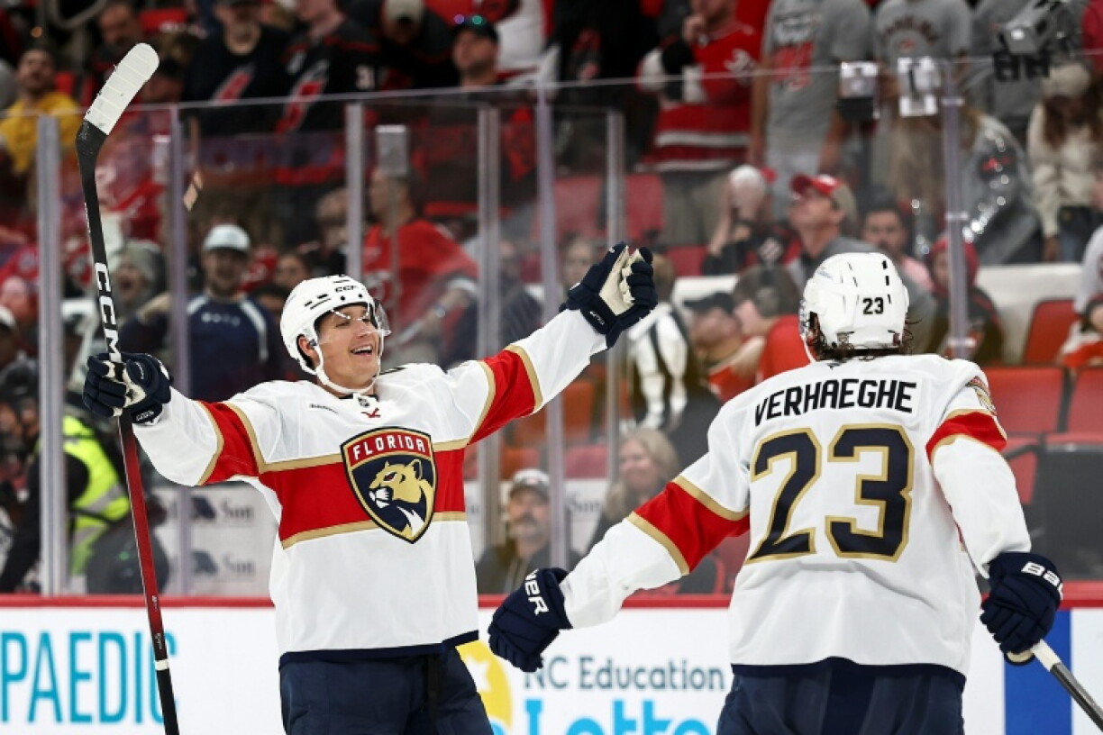 Florida's Gustav Forsling, left, celebrates his game-winning overtime goal with teammate Carter Verhaeghe as the Panthers beat reigning champion Carolina 1-0 in the opening game of the 2026-27 NHL season