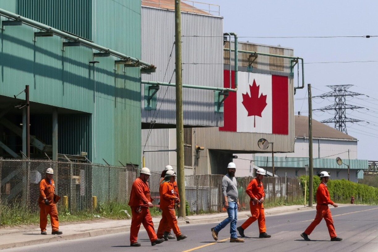Workers cross the street outside a steel plant in Hamilton, Ontario