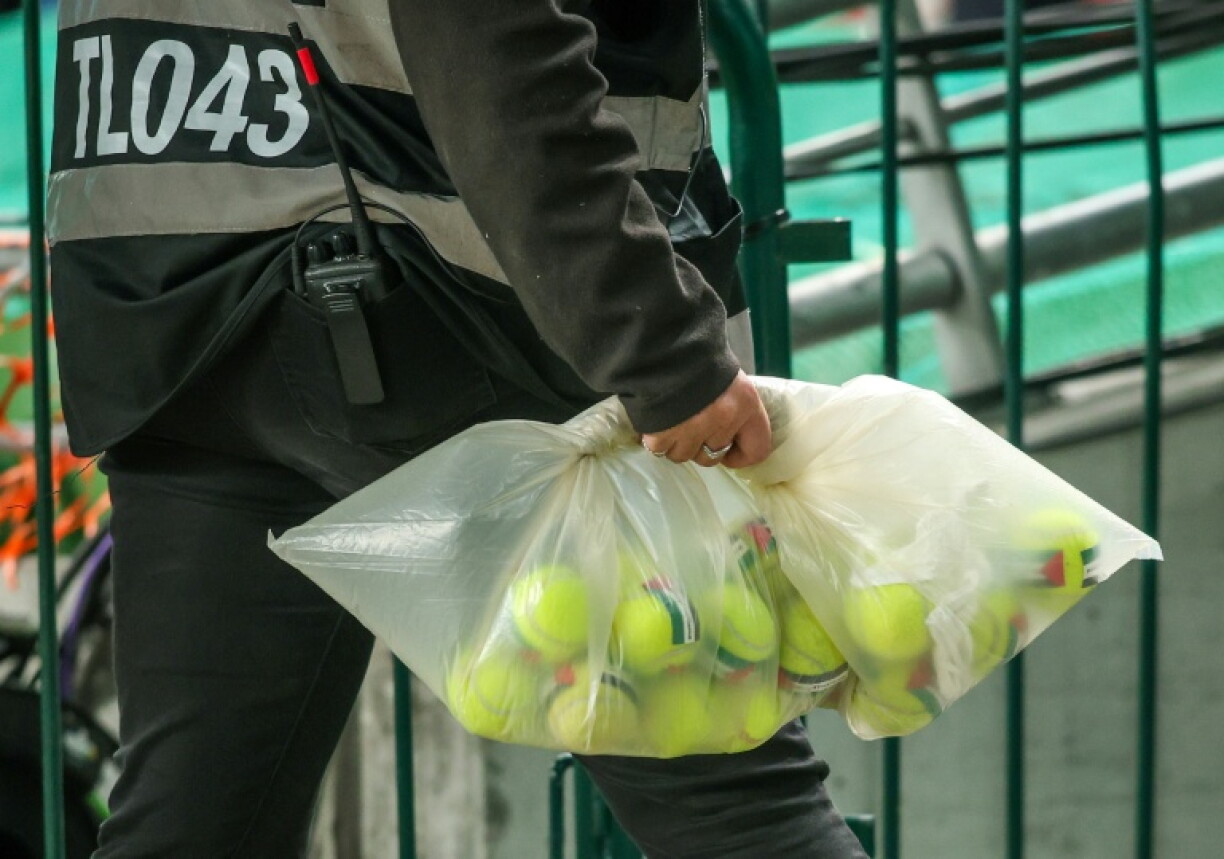 An official collects tennis balls with Palestinian flag stickers thrown onto the pitch during Ireland's game with Austria in Dublin