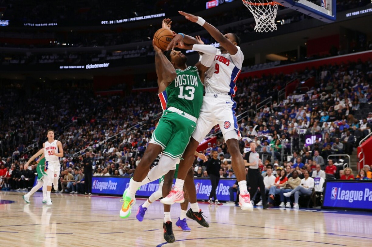 Boston's Paul George, center, drives to the basket against Detroit's Ausar Thompson on his way to scoring a game-high 38 points but the Celtics lost to the host Pistons in the opening game of the NBA season