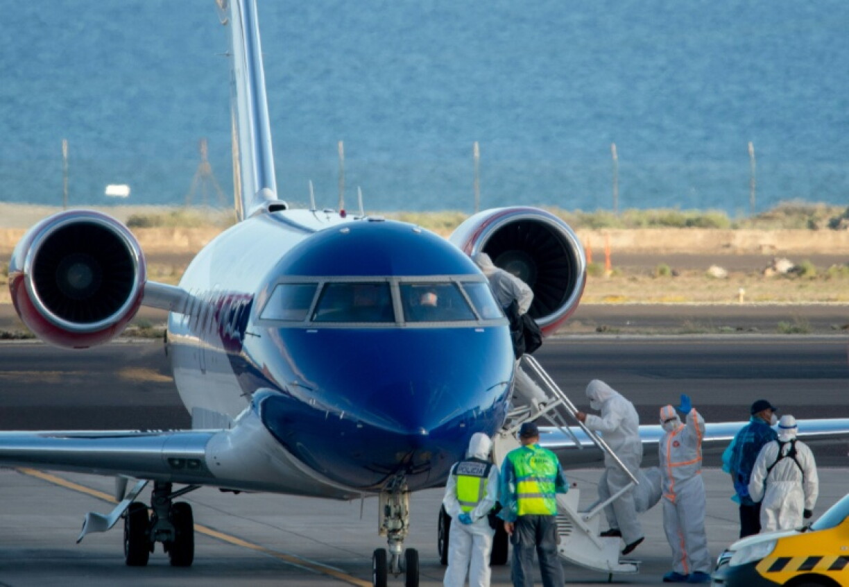 Des passagers du MV Hondius embarquent à bord d'un avion sanitaire à destination des Pays-Bas, le 11 mai 2026 sur l'aéroport de Tenerife Sud, dans l'archipel espagnol des Canaries
