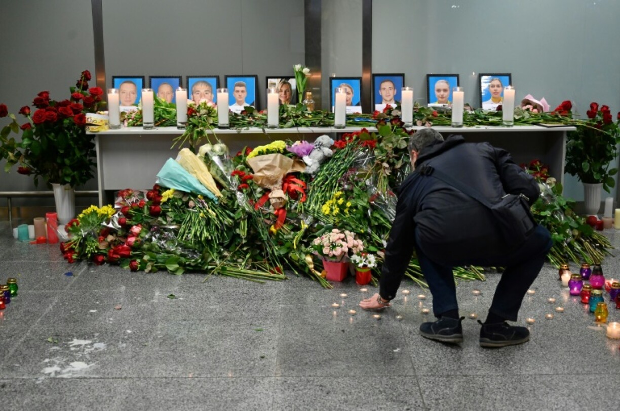 Un homme devant un mémorial en hommage aux victimes ukrainiennes d'un crash aérien en Iran ayant fait 176 morts, à l'aéroport de Kiev Boryspil (Ukraine), le 8 janvier 2020.