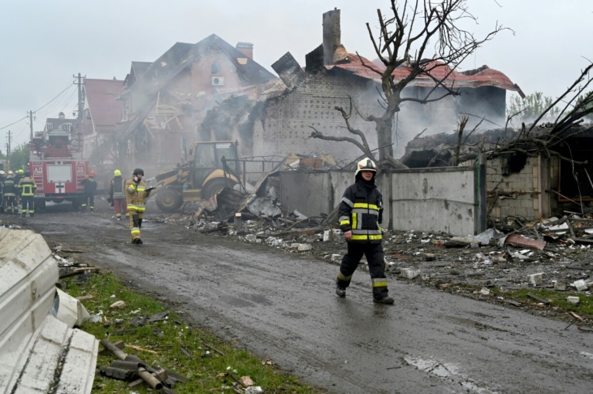 Des pompiers interviennent sur un incendie dans des maisons endommagées par une frappe russe dans la région de Kiev, le 25 mai 2025 en Ukraine