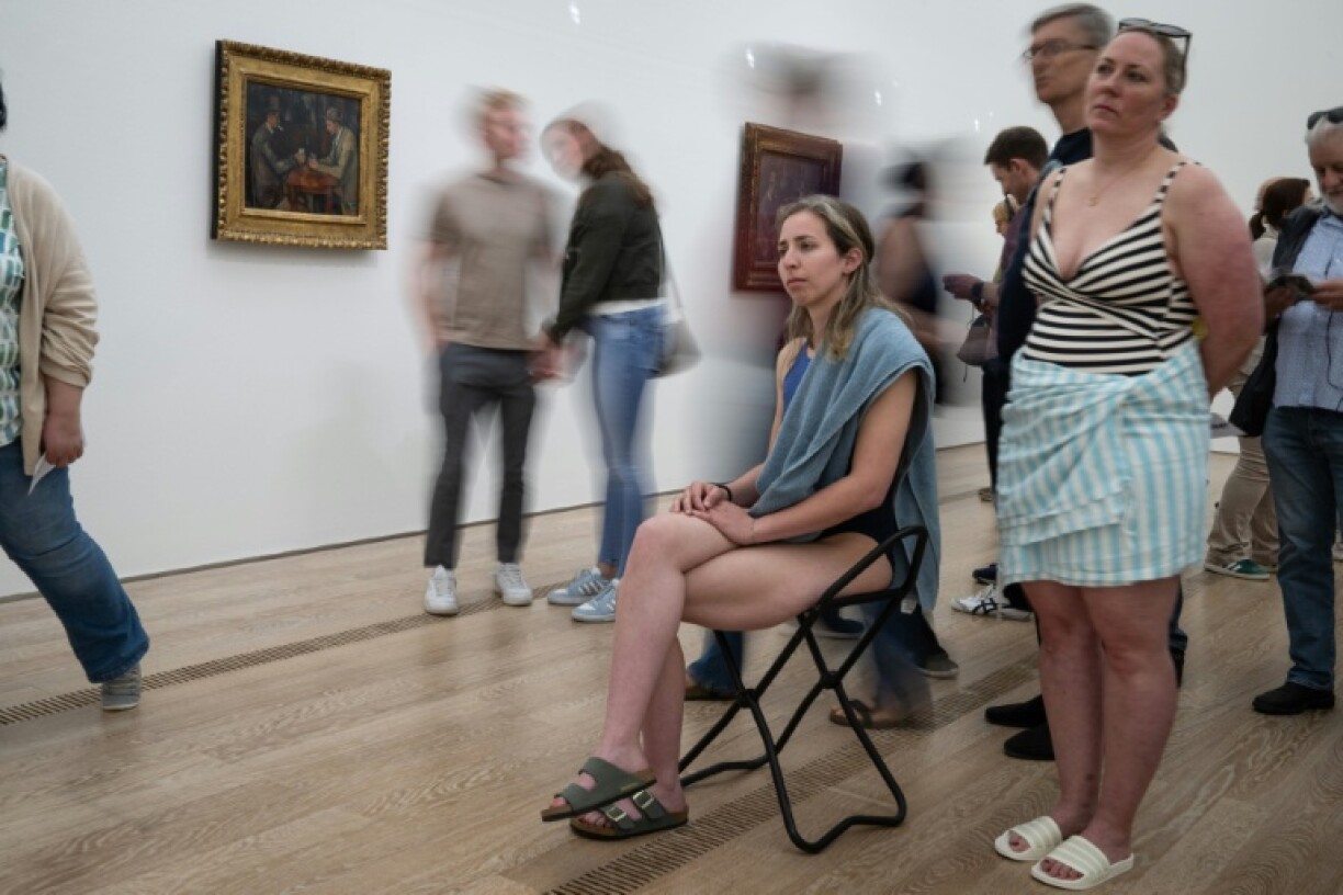 Des visiteurs en maillot de bain devant des tableaux de Paul Cézanne, lors d'un événement inspiré par l'artiste italien Maurizio Cattelan à la fondation Beyeler, près de Bâle, en Suisse, le 1er mai 2026