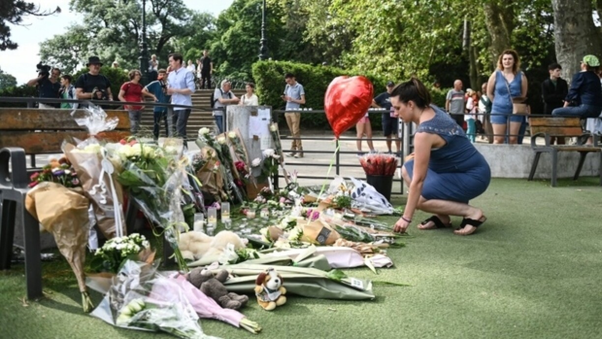 Une femme dépose des fleurs en hommage aux victimes d'une attaque au couteau à Annecy, le 9 juin 2023 aux